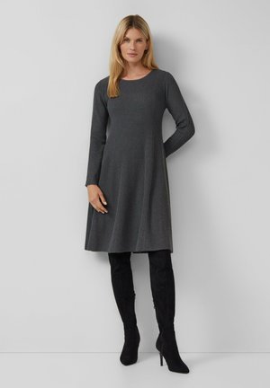 Femme portant une robe en tricot côtelé gris charbon à mi-mollet, à manches longues, associée à des bottes en suede noires à talons hauts au-dessus du genou.