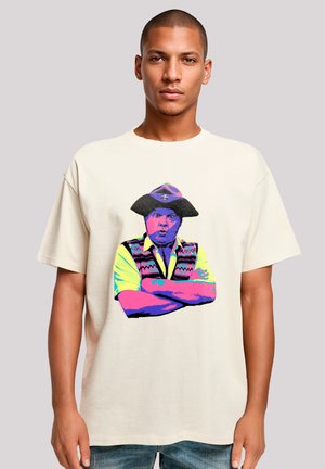 Cream-colored cotton t-shirt featuring a colorful graphic print of a man in a hat, arms crossed, with vibrant design elements.