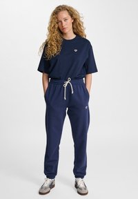 T-shirt blu navy con un piccolo logo e pantaloni comodi a vita elastica, con coulisse e caviglie elastiche.