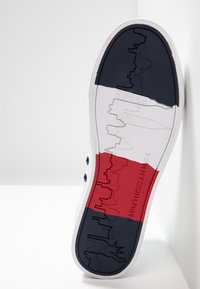 Sole tenisky s trojbarevným designem v námořnické modré, bílé a červené barvě, s vzory městského horizontu a Sochy Svobody. Materiál: guma.