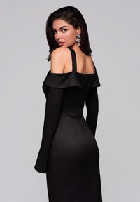 Schwarzes schulterfreies Kleid mit taillierter Silhouette, langen Ärmeln und satinähnlicher Textur. Mit einem Rüschen-Ausschnitt und einem Reißverschluss auf der Rückseite versehen.