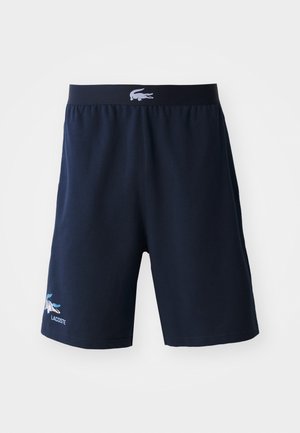 Pantaloni corti blu navy realizzati in tessuto morbido, con una vita nera con logo, tasche laterali e un dettaglio del logo multicolore sull'orlo.