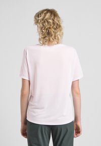 T-shirt rosa chiaro con scollo rotondo e maniche corte, realizzato in tessuto morbido. Il retro è semplice, senza motivi o dettagli.