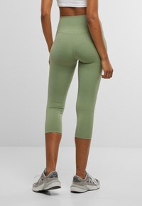 High-waisted, snug fitting capri leggings in lichtgroen, gemaakt van gladde stretchstof. Heeft platte naden en een eenvoudig, minimalistisch ontwerp.