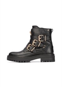 Bottines en cuir noir à talon avec trois boucles dorées réglables, un bout arrondi et une semelle en caoutchouc texturé avec un motif cranté. Détail de fermeture éclair sur le côté.