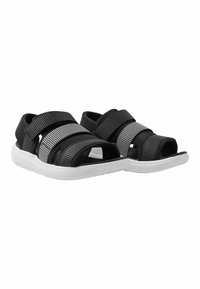 Svarta och grå sandaler med öppen tå, som har två breda remmar och en strukturerad yta, vilande på en vit gummisula.
