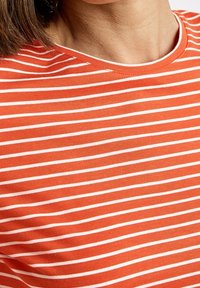 Rot-weiße gestreifte T-Shirt mit kurzen Ärmeln, rundem Ausschnitt und weichem Baumwollmaterial. Streifen gleichmäßig verteilt.