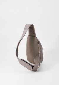 Grå sling taske med en glat overflade, mesh rygpanel, justerbar rem og lynlåslomme. Kompakt og funktionelt design.