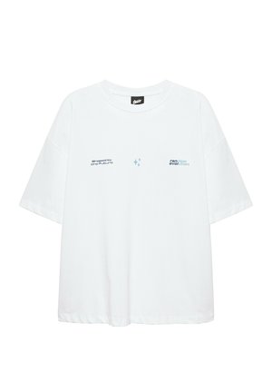 T-shirt blanc oversize à manches courtes avec petit texte "shaped by the future" à gauche et "random evolution" sur la partie droite de la poitrine.