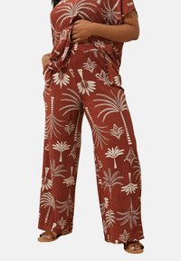 Vinröda vida byxor med vita palmträd och geometriska mönster, med en texturerad tygkvalitet och sidofickor för funktionalitet.