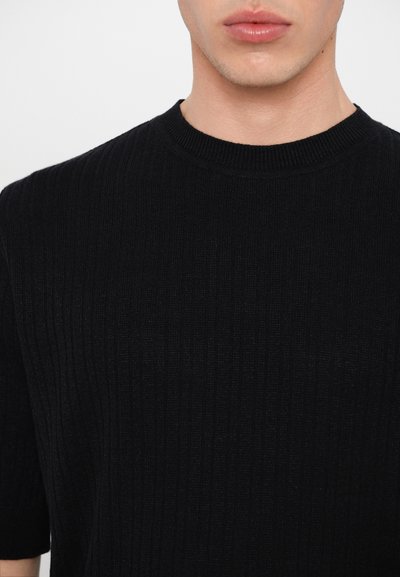 Suéter negro de punto acanalado, de manga corta y cuello redondo. La tela es suave con textura vertical, lo que proporciona una apariencia ajustada.
