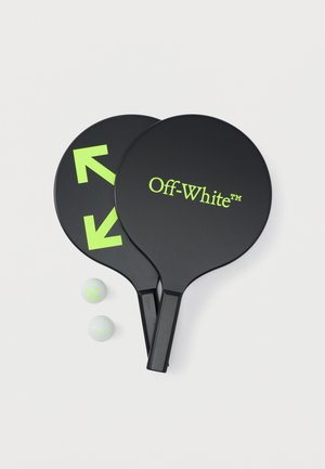 Δύο μαύρα κουπιά με το λογότυπο Off-White, με νεον πράσινα βέλη και κείμενο, δίπλα σε δύο λευκές μπάλες με νεον πράσινα λογότυπα πάνω σε λευκό φόντο.