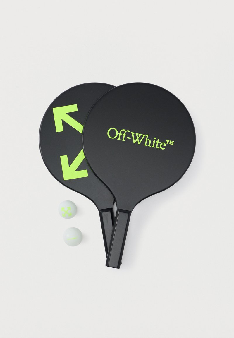 Deux pagayes noires de la marque Off-White avec des flèches et du texte verts néon, accompagnées de deux balles blanches portant des logos verts néon sur un fond blanc.