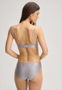 Ensemble de lingerie côtelé gris clair avec des bretelles réglables et une fermeture à crochet. Le design comprend des bords simples et sans coutures.