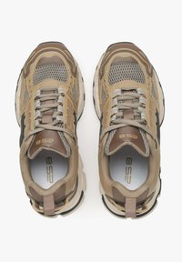 Beżowe i brązowe siatkowe sneakersy z teksturowanym wzorem, z sznurowadłami, wzmocnionym kołnierzem oraz akcentami logo na języku i pięcie.