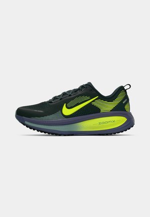 Zapatilla de correr Nike en negro y amarillo neón. Presenta una parte superior de malla transpirable, suela acolchada y un diseño aerodinámico con acentos texturizados.