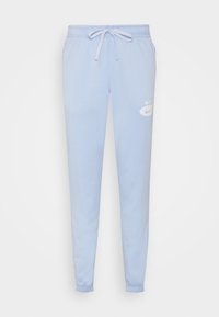 Světle modré tepláky s elastickým pasem a šňůrkou, s bílým logem Nike na levém stehně a s elastickými manžetami u kotníků.