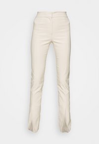 Beige zúžené kalhoty s hladkou texturou, vysokým pasem a viditelnými předními švy. Mají rozparky na lemu pro přidaný detail.