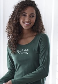Long-sleeve green shirt with a scoop neckline and white text "life is a collection of moments" featuring soft, smooth fabric texture.