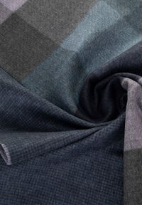 Wollen stof met een zachte textuur, met een kleurenpalet van donkerblauw, grijs en teal in een geruit patroon.