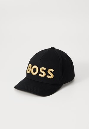 Schwarze Baseballkappe mit vorne in großen goldenen Buchstaben besticktem Schriftzug "BOSS", dargestellt vor einem einfachen weißen Hintergrund.