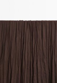 Tissu de rideau plissé marron, présentant des plis verticaux avec une texture lisse. Le haut a un bandeau froncé pour l'accrochage.
