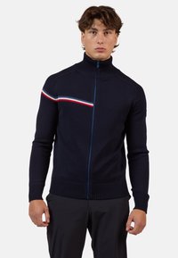 Maglione zip-up blu navy con colletto alto, caratterizzato da una striscia orizzontale rossa, bianca e blu sul petto, con polsini e orlo a coste.