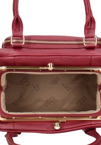 Borsa a mano in pelle rossa con chiusura a zip e dettagli in metallo color oro. Interno foderato in cotone con stampa ripetuta del logo del marchio.