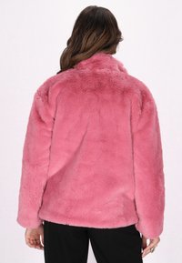 Rosa faux fur jakke med en blød, struktureret overflade, med lange ærmer og en høj krave, vist fra ryggen.