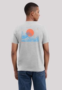 Gray cotton t-shirt featuring a blue wave graphic with an orange sun on the back. Short sleeves, round neckline, and relaxed fit.