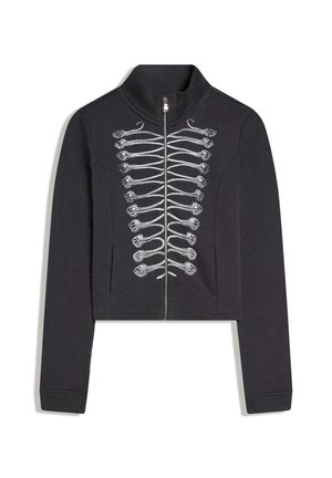 Čierna bunda na zips s bielym vyšívaným vojenským vzorom na prednej strane, stojatý golier, dlhé rukávy a bočné vrecká.