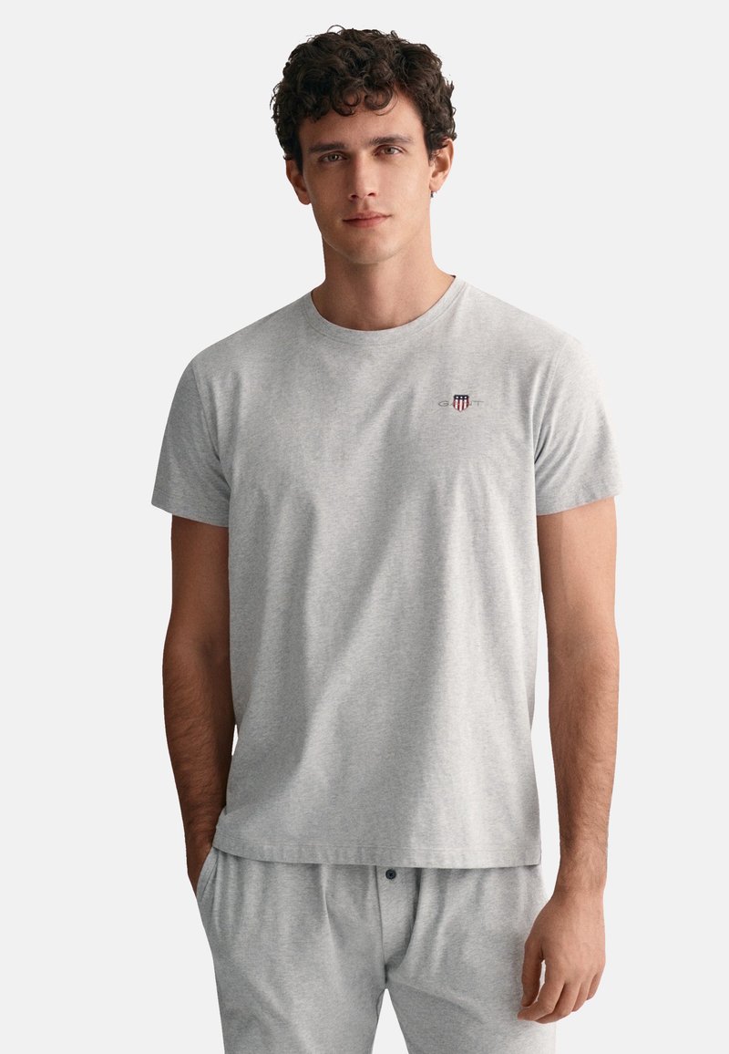Gray cotton t-shirt featuring a crew neck, short sleeves, and a small embroidered logo on the chest. Smooth texture and relaxed fit.