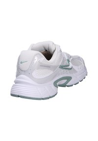 Scarpa sportiva bianca con tomaia in rete, dettagli verdi e suola imbottita. Caratterizzata da una sovrapposizione testurizzata e un colletto imbottito.