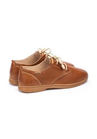Scarpe in pelle marrone con punta tonda, suola in gomma beige, cuciture leggere e lacci beige. Finitura liscia con un sottile dettaglio logo sul lato.