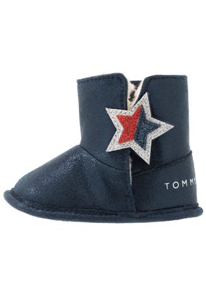 Granatowy but dla malucha z białym futerkiem, błyszczącą czerwoną i niebieską gwiazdką oraz napisem „TOMMY” na pięcie.