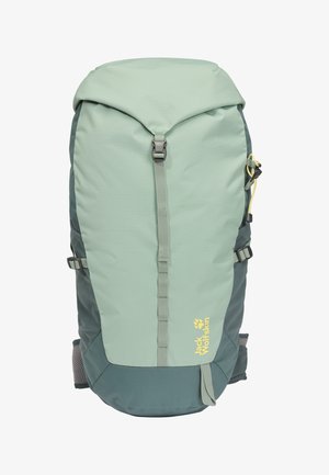 Mochila de senderismo en verde claro y verde oscuro con hebilla frontal, correas laterales, bolsillos de malla y logo amarillo de Jack Wolfskin.