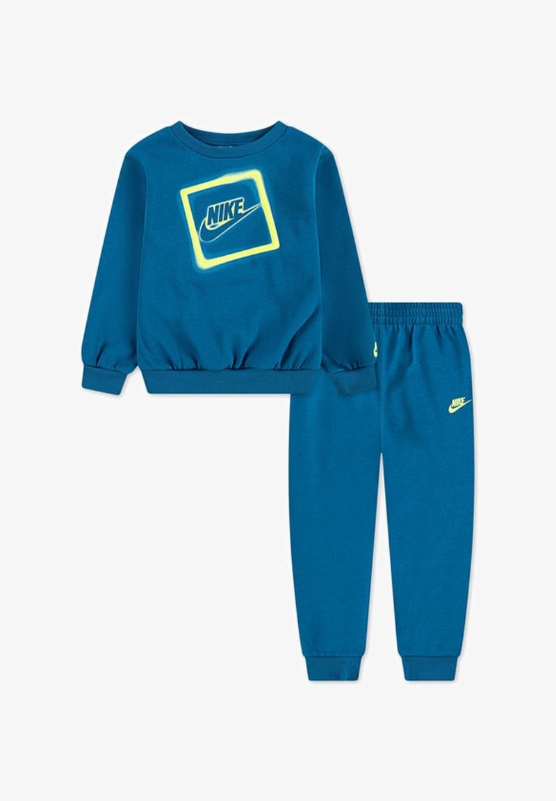 Felpa di cotone blu con polsini a coste, con logo Nike giallo neon in un quadrato. Pantaloni della tuta blu coordinati con logo sull'orlo.