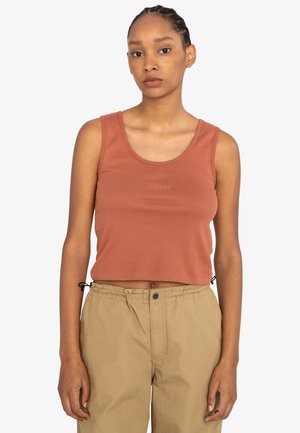 Rust-colored cropped tank top made of ribbed fabric, featuring a round neckline and embroidered logo on the front. Paired with tan drawstring pants.