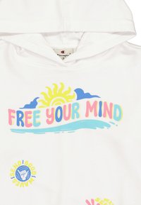 Felpa bianca con testo colorato "LIBERA LA TUA MENTE" accompagnato da un grafico di un sole, onde e un gesto della mano. Realizzata in tessuto morbido, con design casual.