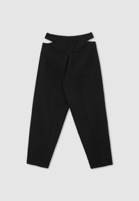 Pantalons noirs ajustés à taille haute, présentant des découpes à l'arrière, deux poches arrière et un design à jambe droite.