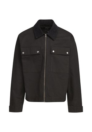 Sort lynlåsjakke med kordfløjlskrave, to brystlommer med klap og sølvtryklåse, samt lange ærmer med manchetter.