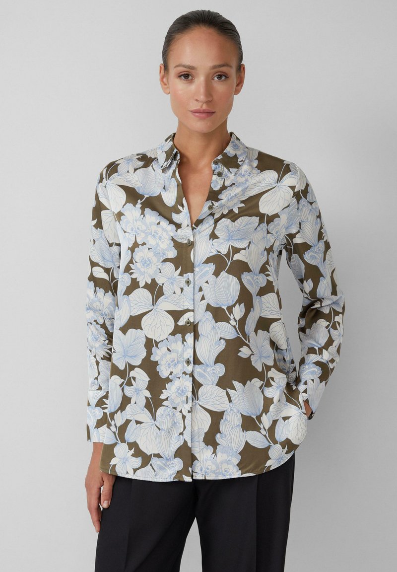 Camicia a maniche lunghe botton-up floreale in verde oliva con motivi floreali blu chiaro e bianchi. Presenta un colletto classico e una texture liscia.