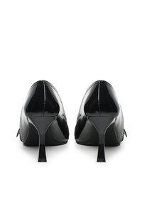 Escarpins en cuir verni noir avec des bouts pointus et des talons aiguilles fins. Texture lisse et embellissements minimaux.