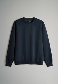 Granatowa bluza z okrągłym dekoltem, ściągaczami na rękawach i dole. Gładki materiał o miękkiej fakturze, bez widocznych wzorów czy ozdób.