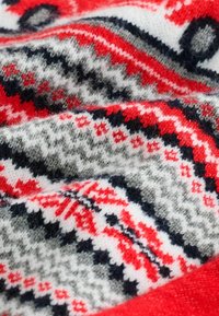 Knit fabric in red, gray, and black featuring geometric patterns, textures, and a soft finish. Predominantly white background with accents.