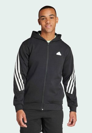 Zwarte zip-up hoodie van zacht stof, met witte drie-strepen accenten op de mouwen en een klein logo op de borst.