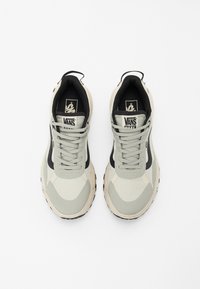 Vans-sneakers med et lyst grått og svart design, mesh- og syntetiske materialer, flate lisser og svart gummisåle.