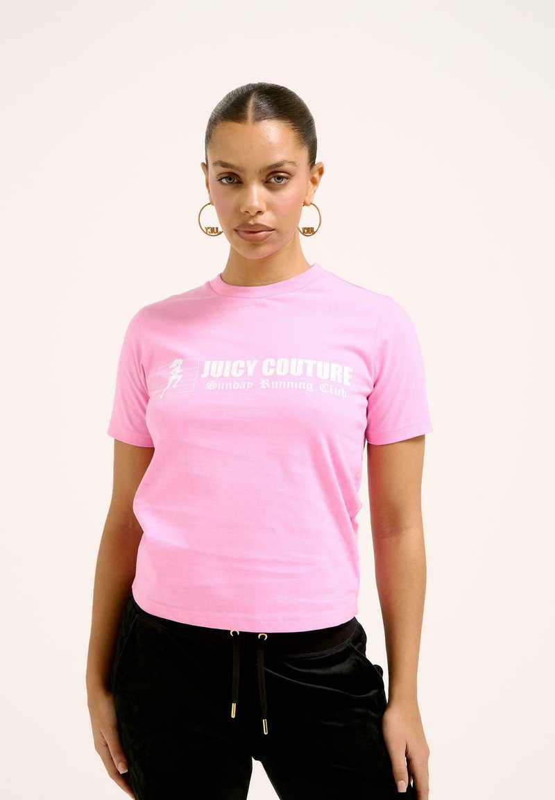 Rozā Juicy Couture T-krekls ar apaļu kakla izgriezumu, uz kura ir balti burti "Juicy Couture Sunday Running Club." Mīksta kokvilnas auduma, kroplēta piegriezuma.