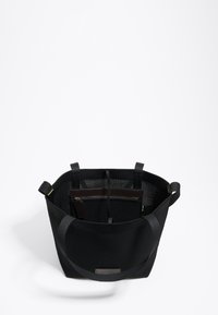 Juoda tinklinė rankinė su dviem tvirtomis petnešomis. Yra vidinė užtrauktuko kišenė ir tekstūruotas paviršius su stačiakampiu dugnu.