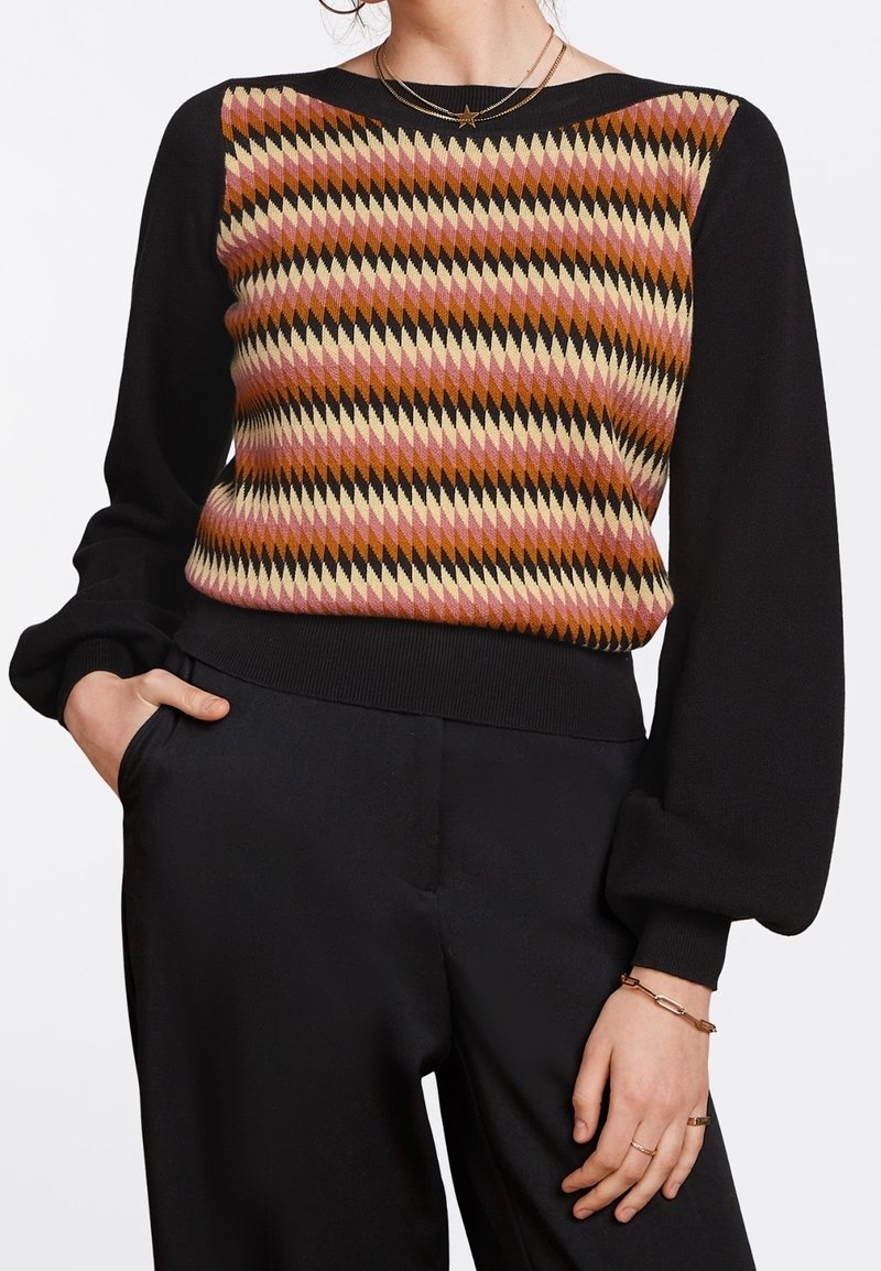 Pull tricoté avec un motif géométrique dans des nuances de rose, de marron et de crème sur le devant, manches et bas noirs, poignets côtelés.